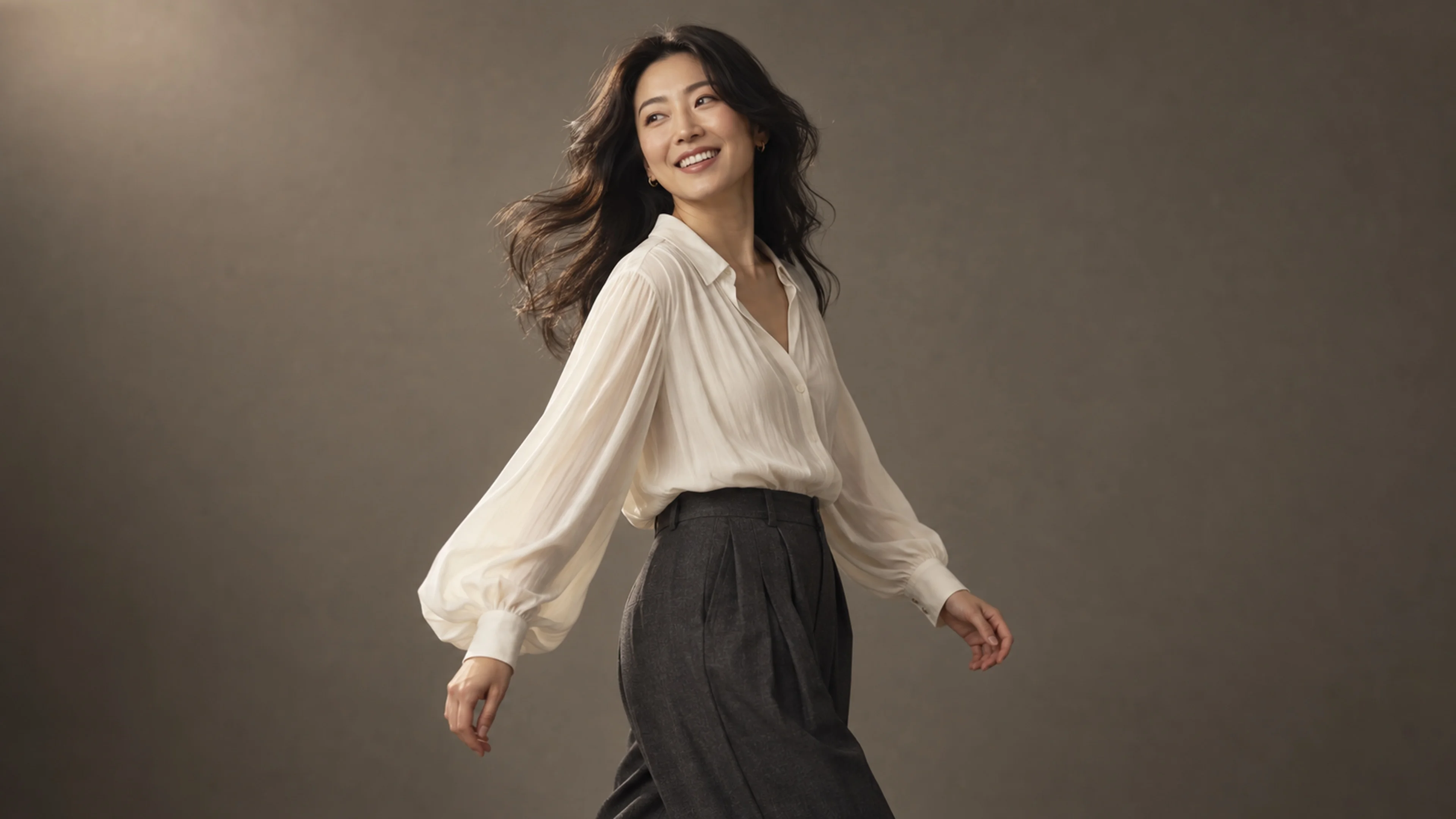 A woman in an ivory blouse turning naturally during a studio portrait session
